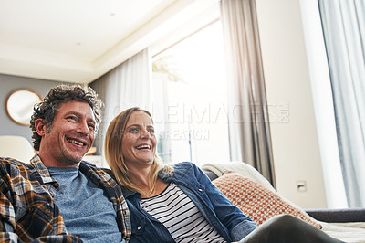 Buy stock photo Laughing couple, relax and watching tv in home for funny movie, comedy show and media connection in lounge. Mature man, happy woman and smile for television, video subscription and streaming platform