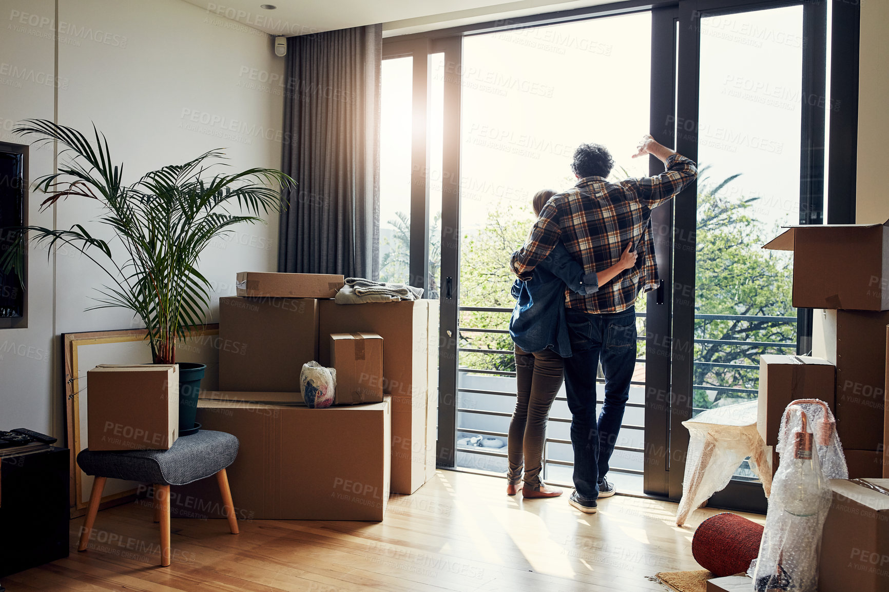 Buy stock photo Rearview shot of a relaxed middle aged couple holding each other while looking out on their balcony together at their new home