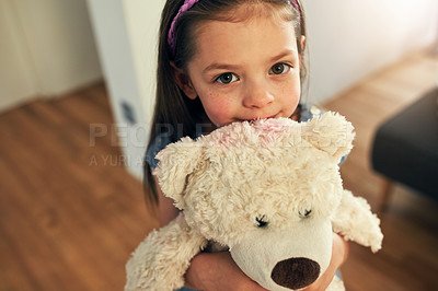 Buy stock photo High angle portrait of an adorable little girl tightly hugging her teddy at home during the day