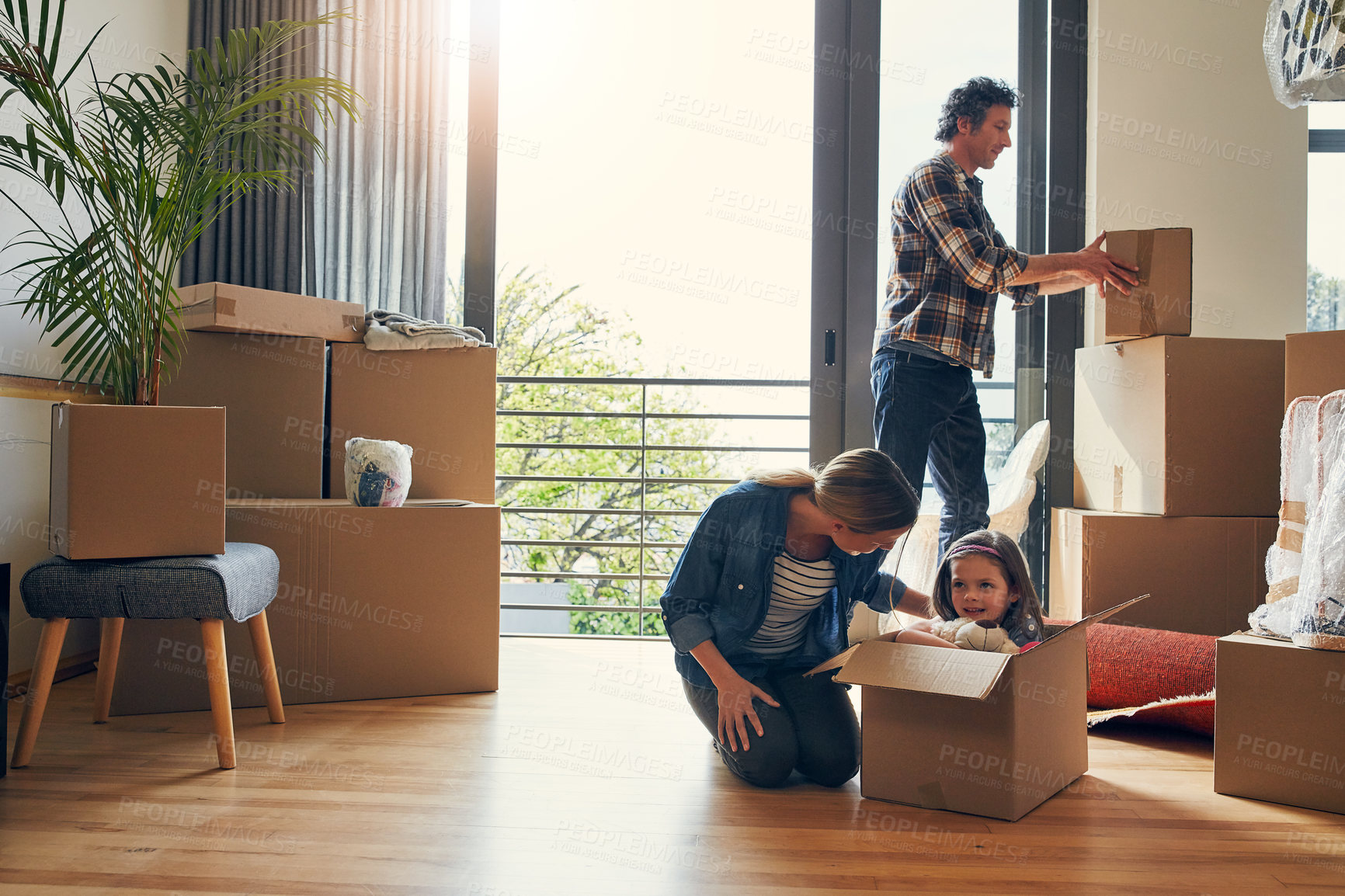 Buy stock photo Moving, boxes and parents with kid in new home bonding together for family time at property. Relocation, mortgage and girl child play with mom and dad and unpacking cardboard package for house.