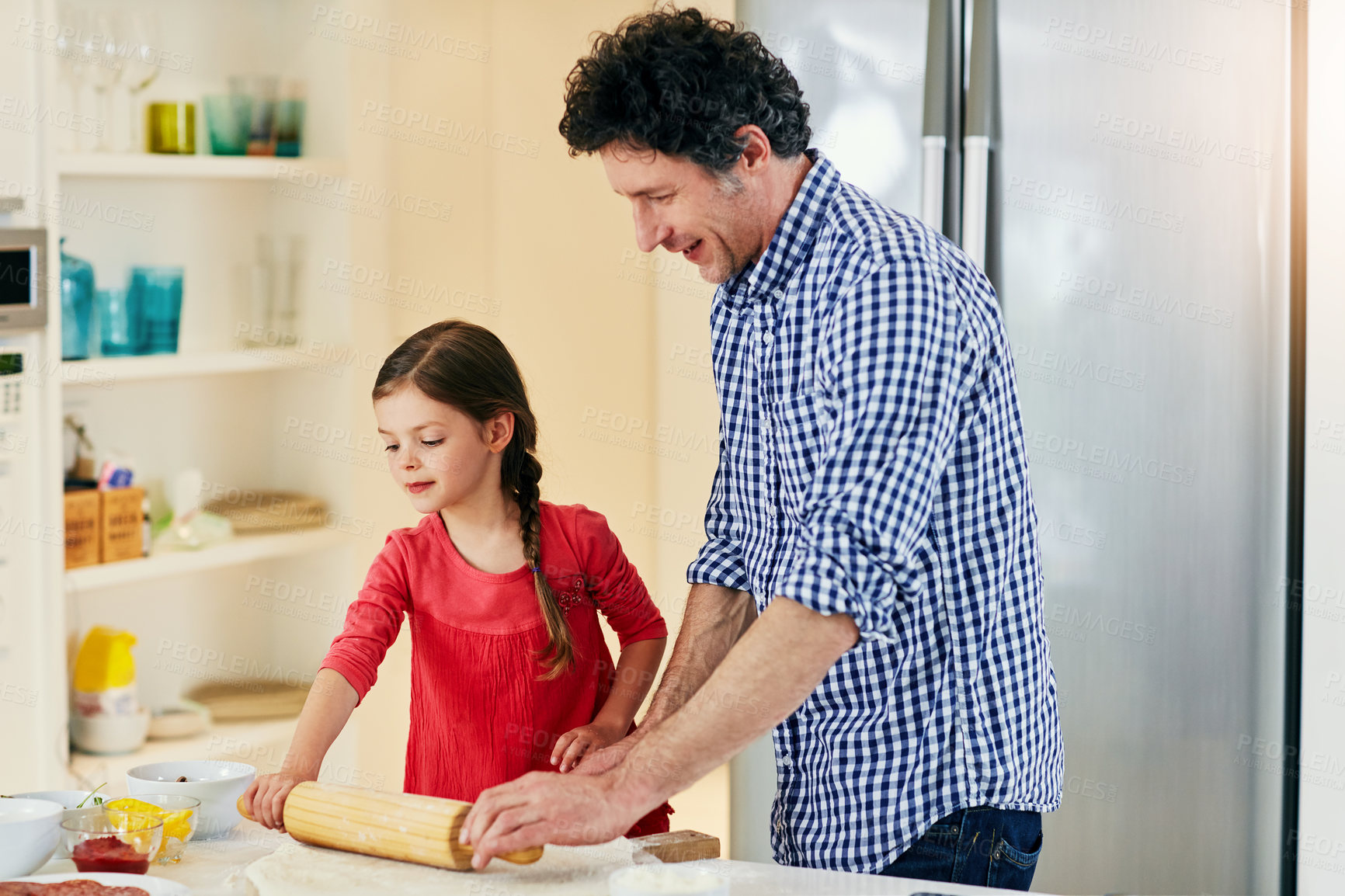 Buy stock photo Shot of a middle aged father and his daughter preparing a pizza to go into the oven in the kitchen at home