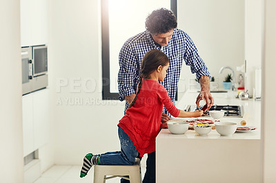 Buy stock photo Shot of a middle aged father and his daughter preparing a pizza to go into the oven in the kitchen at home