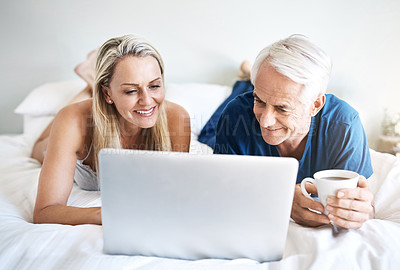 Buy stock photo Happy couple, mature or laptop in bed for movie choice and streaming option online on sofa in home. Relax, smile and people in bedroom to chill on social media app on digital website or technology