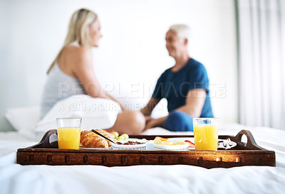 Buy stock photo Breakfast, couple and tray on bed with food, juice and nutrition in morning for relax, bonding and love. Healthy meal, diet and mature people in home with croissant, bacon and plate for brunch snack