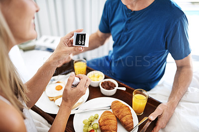 Buy stock photo Shot of a mature man gifting his wife with a pair of earrings and breakfast in bed at home