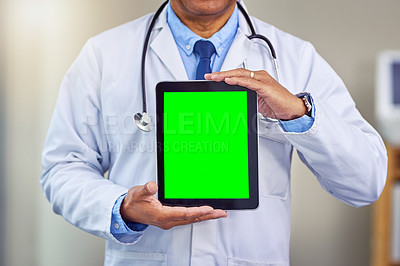 Buy stock photo Shot of an unrecognizable male doctor holding up a digital tablet in front of him while standing inside of a hospital during the day