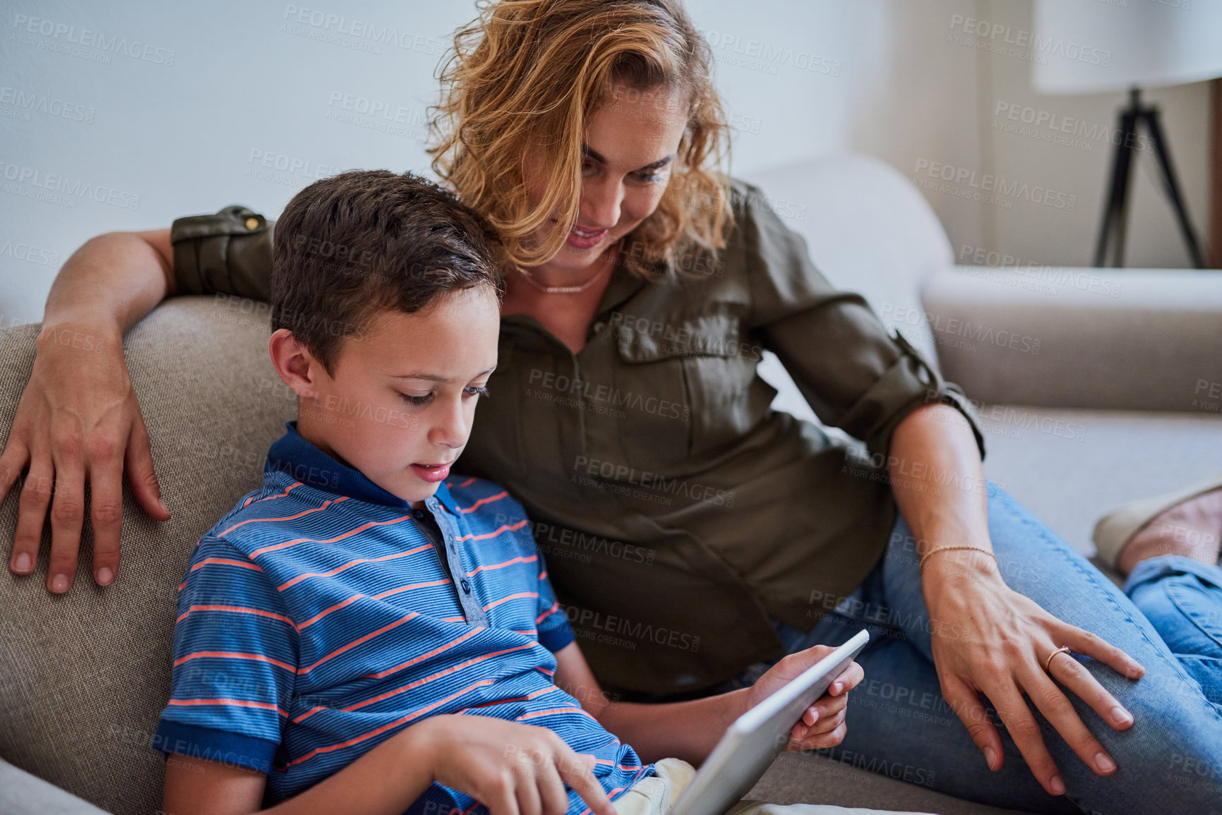 Buy stock photo Cropped shot of a mother and her adorable son using a tablet together on the sofa at home