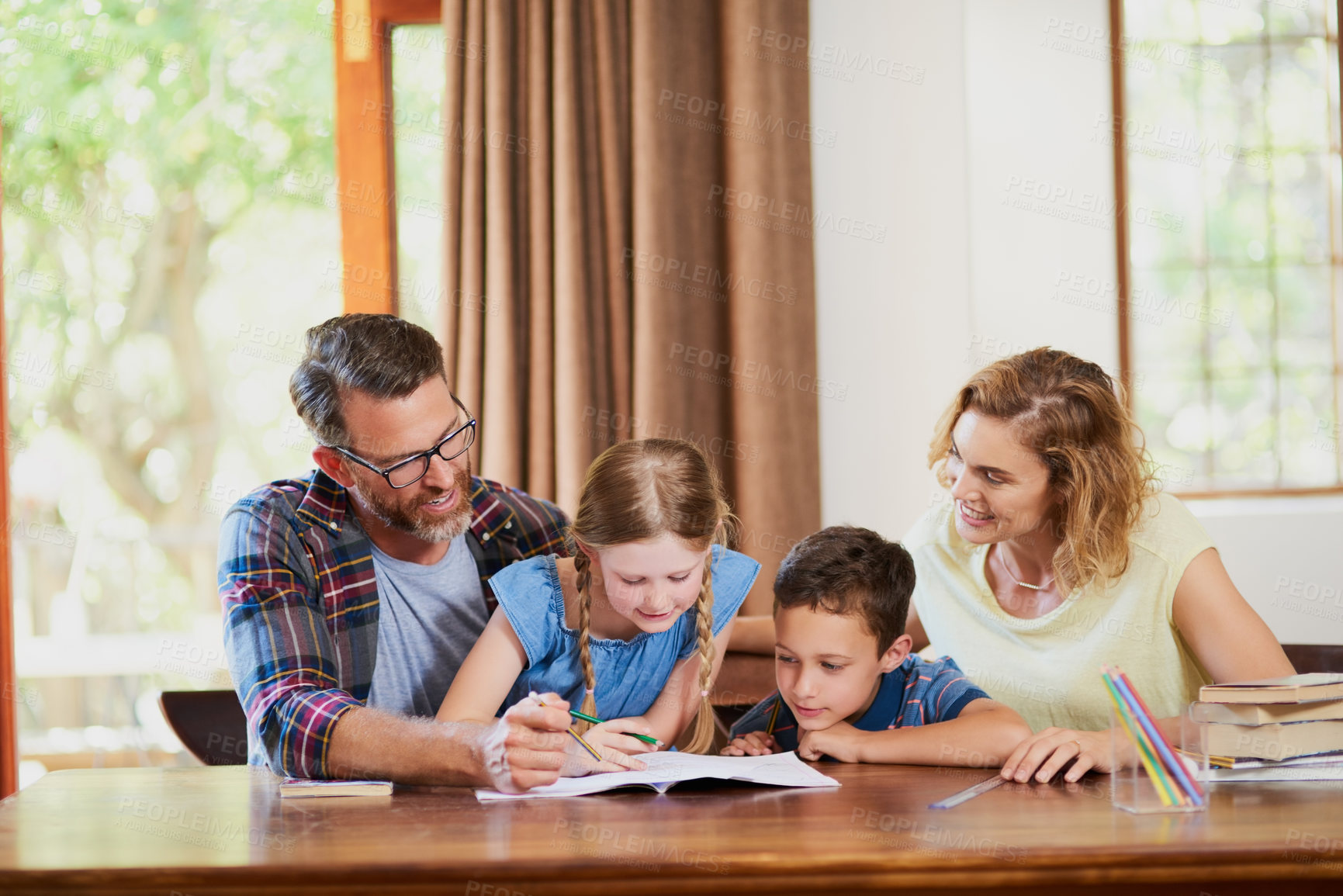 Buy stock photo Cropped shot of two parents helping their adorable children with schoolwork at home