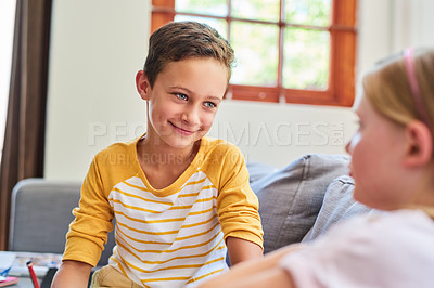 Buy stock photo Cropped shot an adorable brother and sister doing schoolwork together on the sofa at home