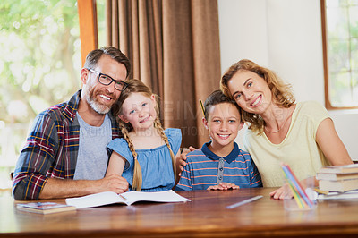 Buy stock photo Cropped shot of an affectionate family doing schoolwork together at home