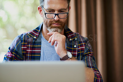 Buy stock photo Cropped shot of a handsome mature man using a laptop at home