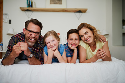 Buy stock photo Portrait of a happy family lying on the bed in the bedroom at home