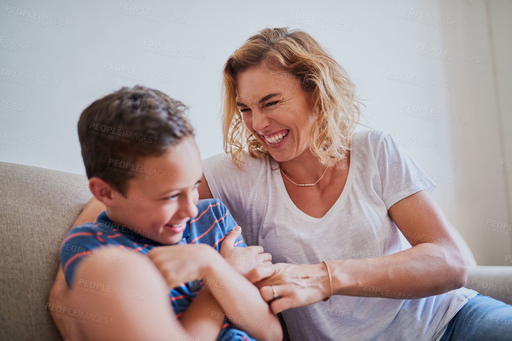 Buy stock photo Cropped shot of a mother tickling her son on the sofa at home