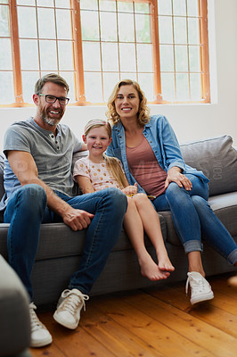 Buy stock photo Shot of a mother and father with their adorable daughter on the sofa in the living room at home
