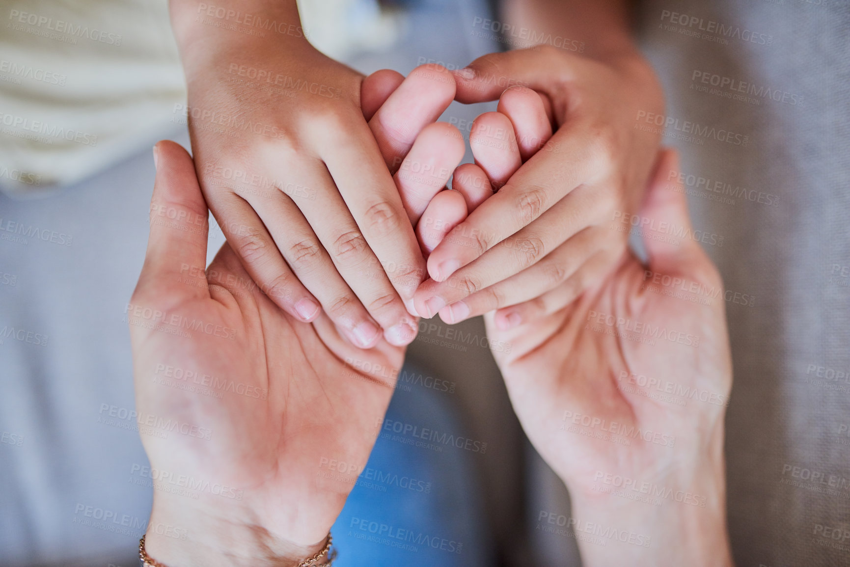 Buy stock photo High angle shot of a mother and son holding hands at home
