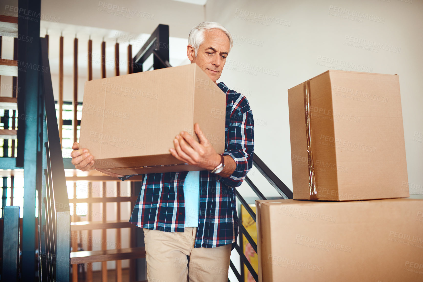 Buy stock photo Shot of a handsome mature man carrying a box on moving day