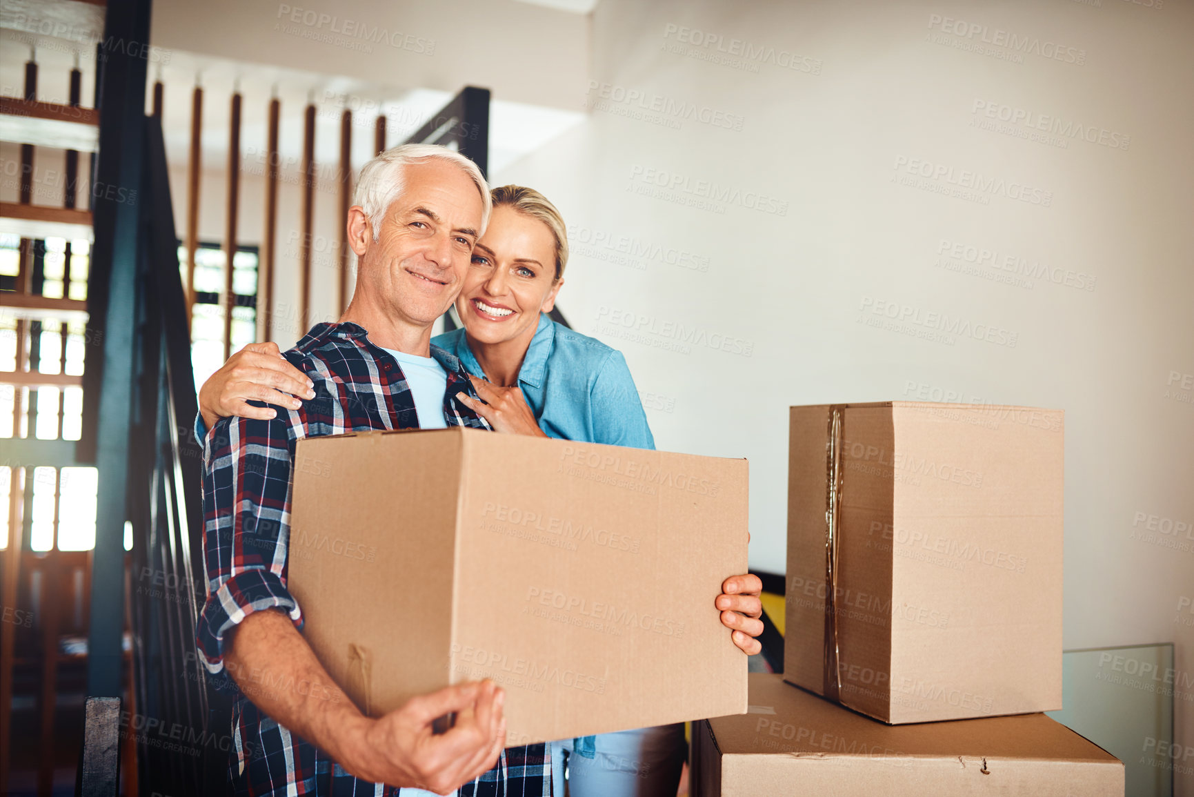 Buy stock photo Portrait of a happy mature couple carrying boxes on moving day