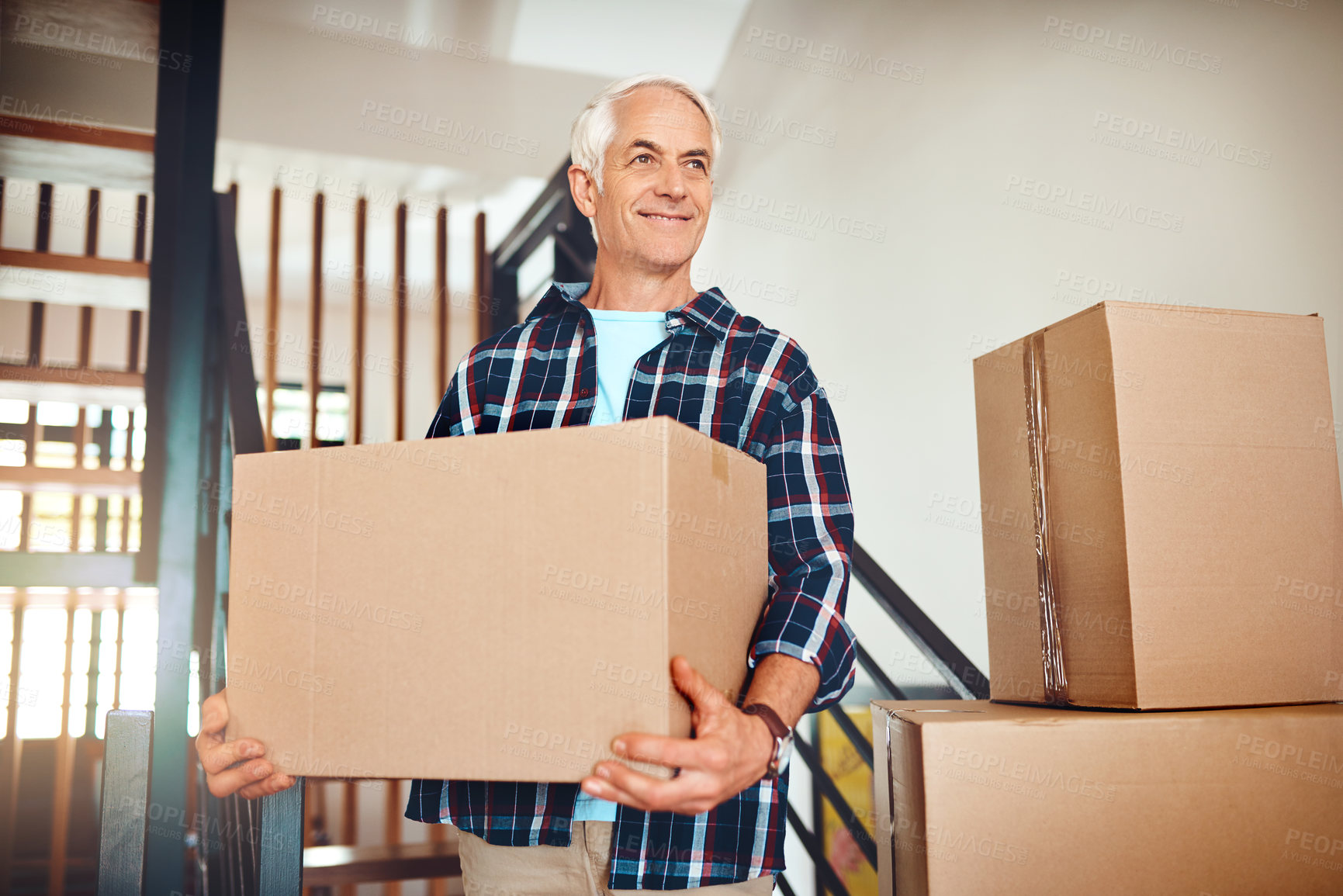 Buy stock photo Shot of a handsome mature man carrying a box on moving day