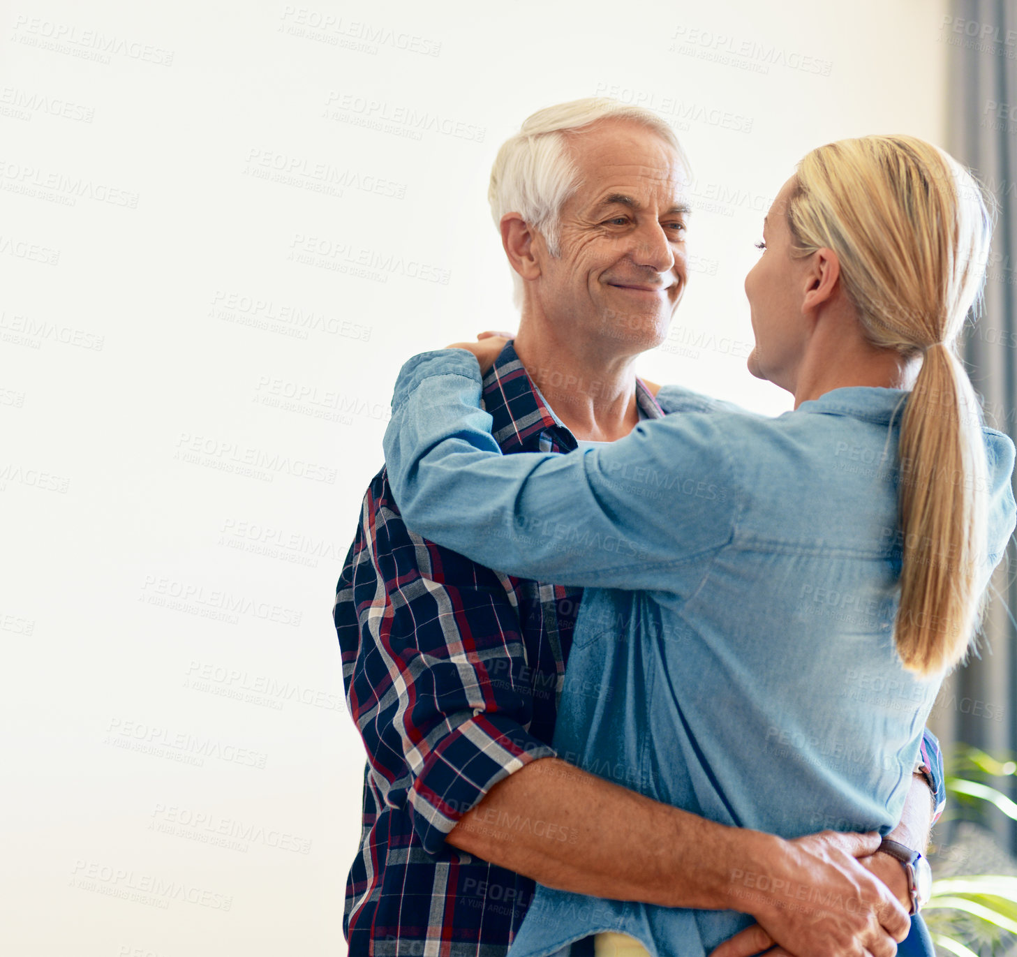 Buy stock photo Shot of an affectionate mature couple embracing at home