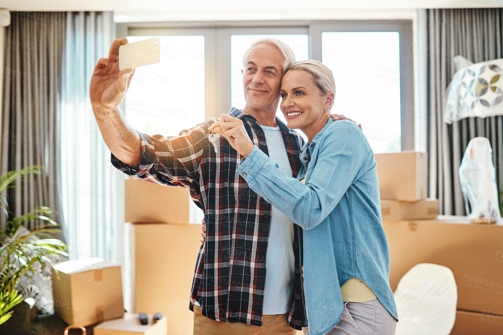 Buy stock photo Shot of a happy mature couple taking a selfie on moving day