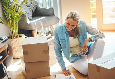 Buy stock photo Shot of a mature woman going through paperwork on moving day