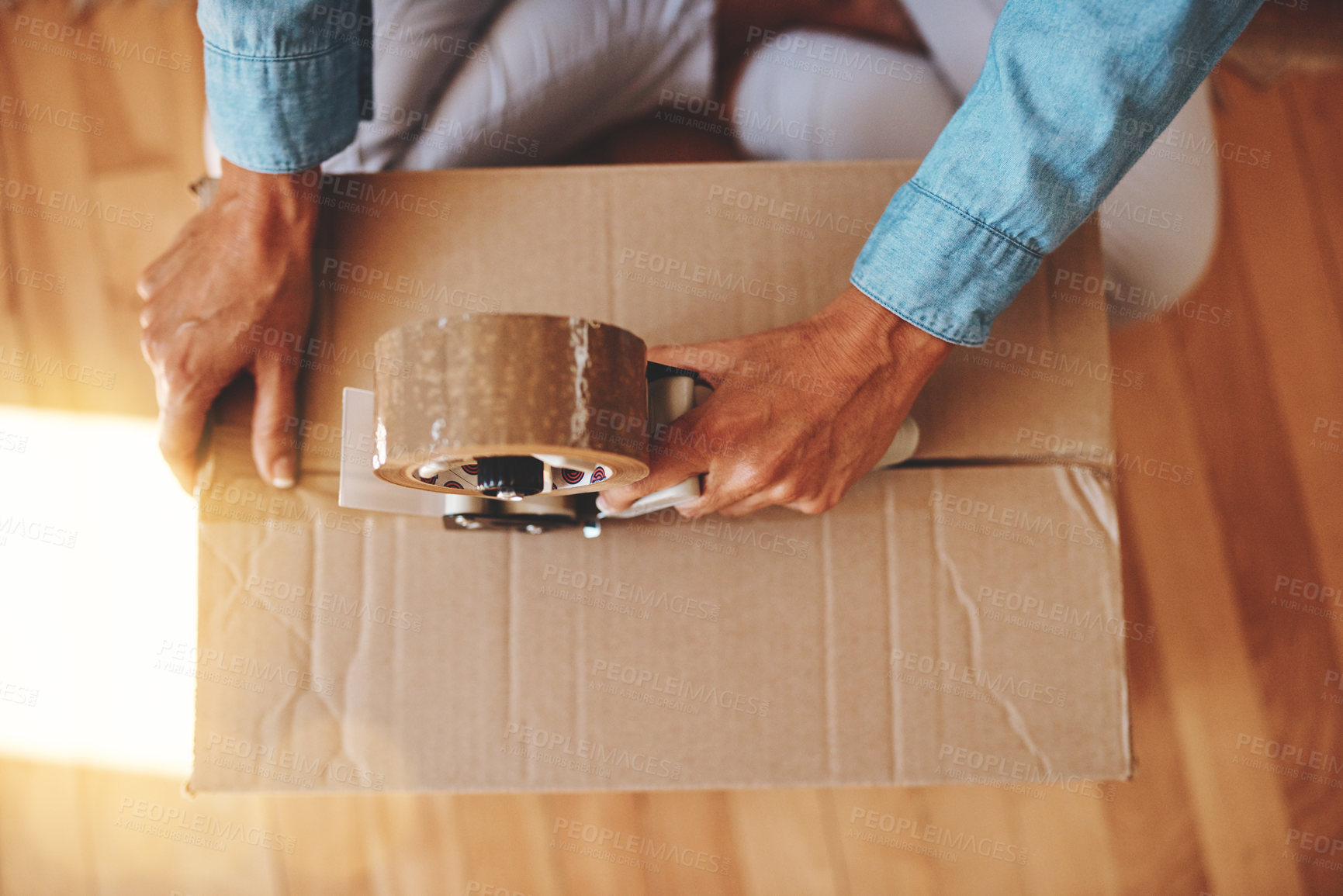 Buy stock photo Cropped shot of a woman sealing a box with adhesive tape at home