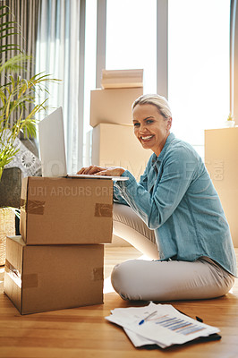 Buy stock photo Portrait of a mature woman using a laptop on moving day