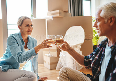 Buy stock photo Shot of a happy mature couple toasting with wine on moving day