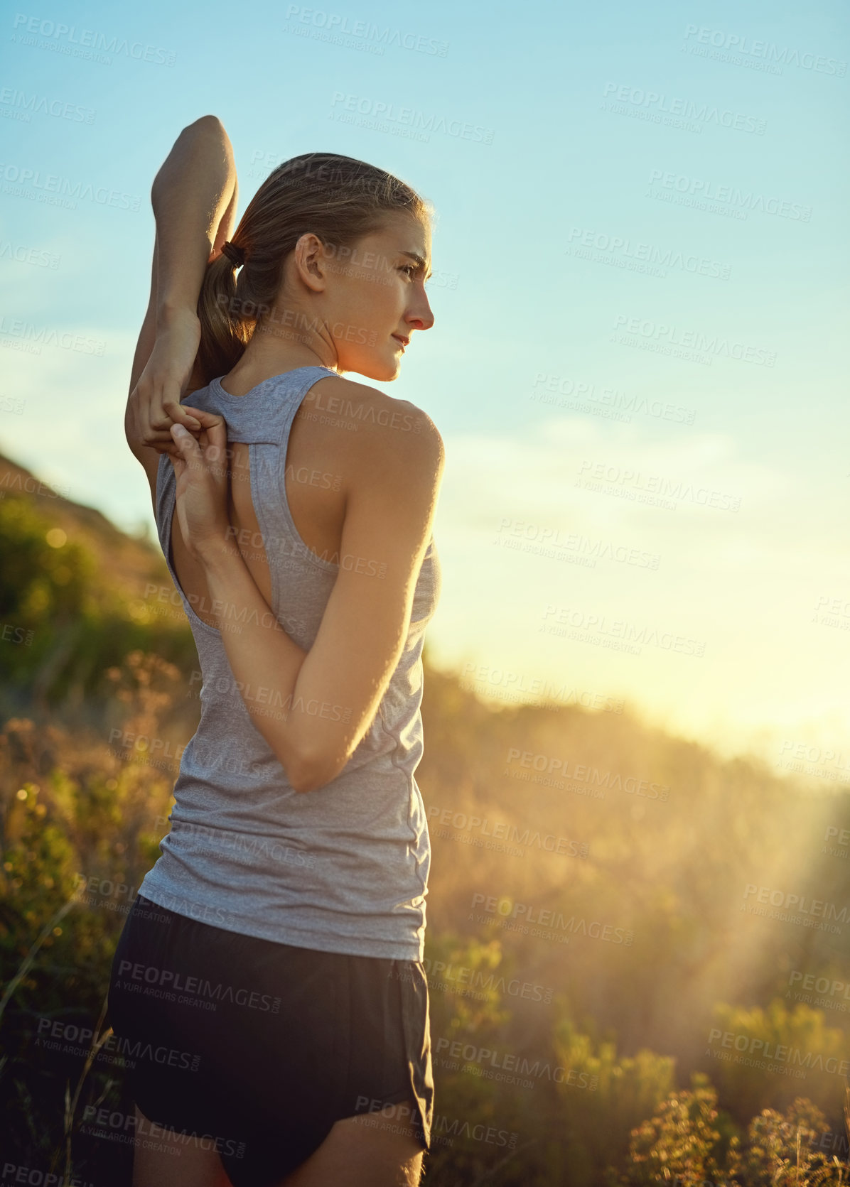 Buy stock photo Shot of a young woman stretching before a run outdoors