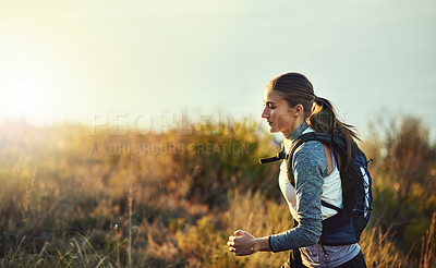 Buy stock photo Shot of a young woman out for a run along a mountain trail