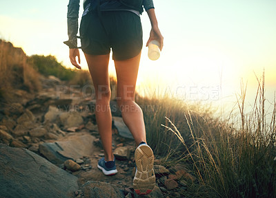 Buy stock photo Rearview shot of an unrecognizable woman out for a run along a mountain trail