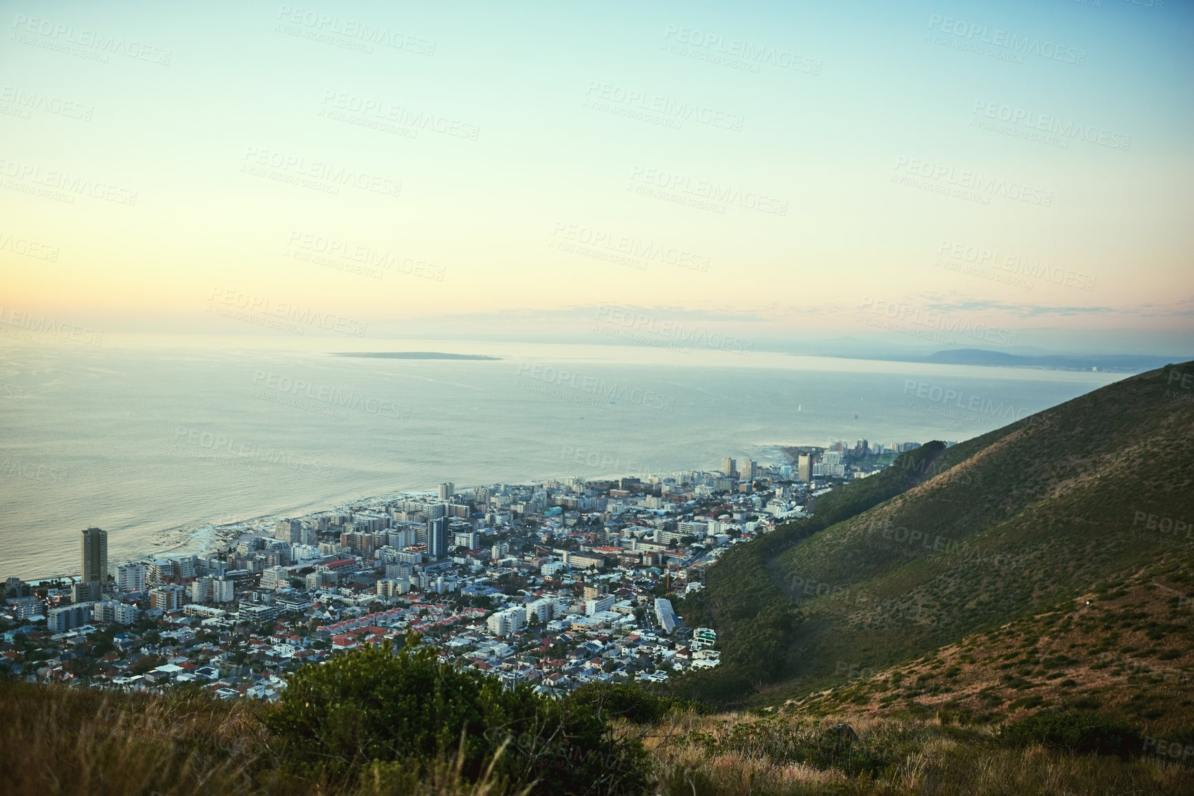 Buy stock photo Shot of the view of a city along the ocean from a mountain peak
