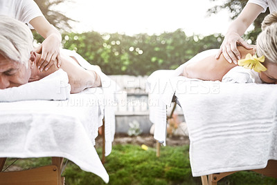 Buy stock photo Shot of a middle aged couple having a relaxing massage together at a spa during the day