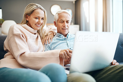 Buy stock photo Cropped shot of mature couple using a laptop on the sofa at home