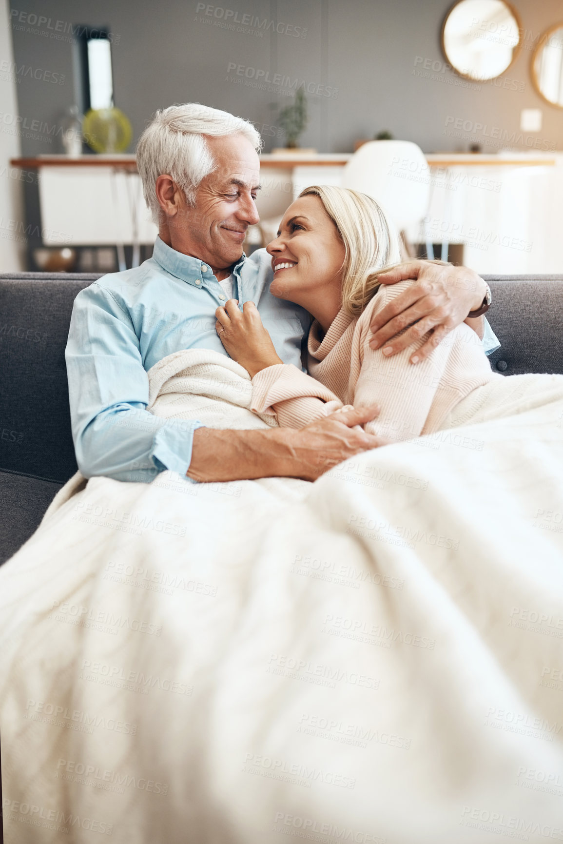 Buy stock photo Cropped shot of an affectionate  mature couple relaxing on the sofa at  home