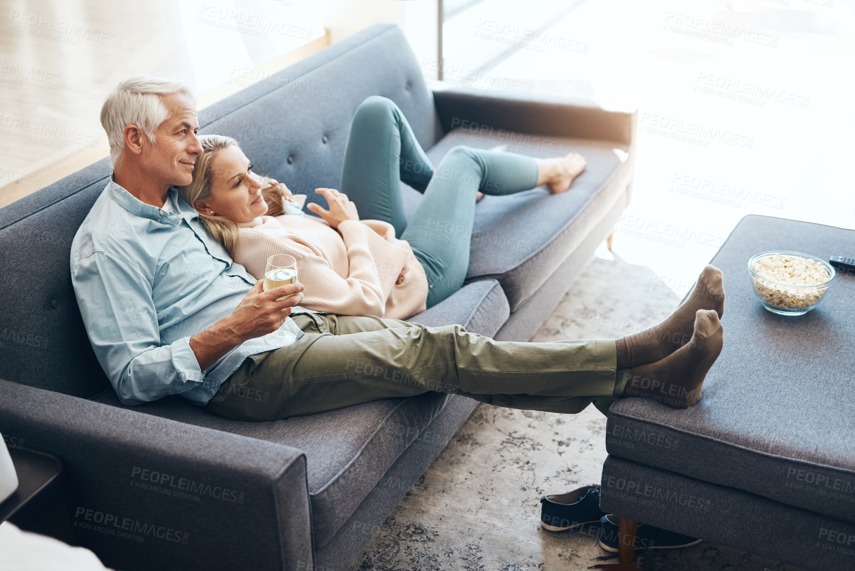Buy stock photo Shot of an affectionate mature couple relaxing on the sofa at home