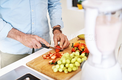 Buy stock photo High angle shot of an unrecognizable mature man preparing a healthy snack at home