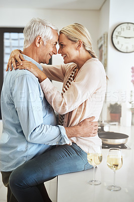Buy stock photo Cropped shot of an affectionate mature couple sharing an intimate moment in their kitchen