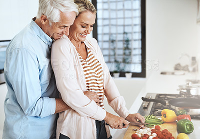 Buy stock photo Cropped shot of an affectionate mature couple preparing a healthy meal at home