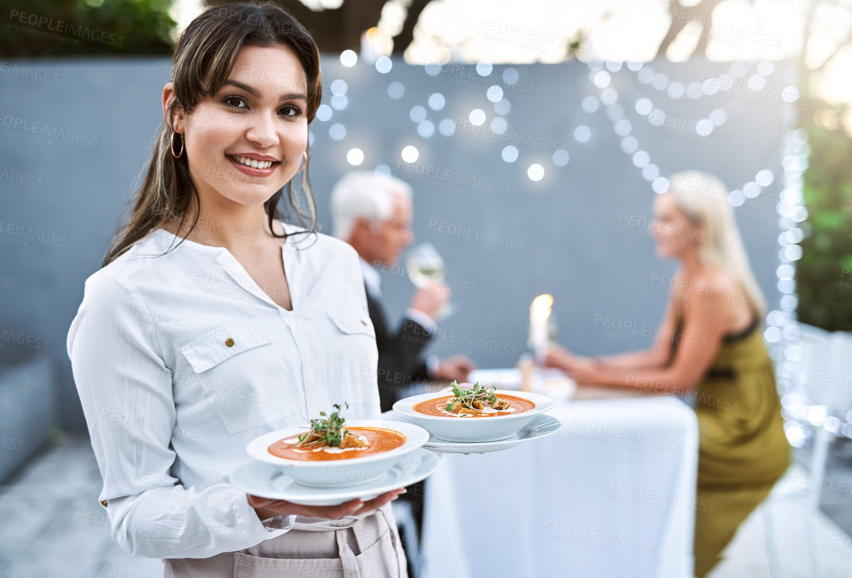 Buy stock photo Shot of a young waitress serving a mature couple on a romantic date