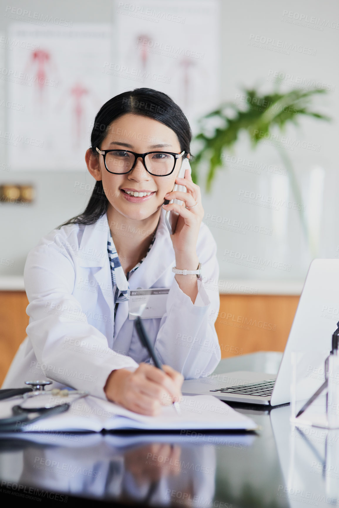 Buy stock photo Cropped portrait of a young female doctor making notes while working in a hospital