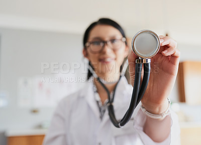 Buy stock photo Cropped shot of a young female doctor reaching out with a stethoscope to listen to your heartbeat