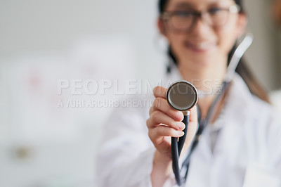 Buy stock photo Cropped shot of a young female doctor reaching out with a stethoscope to listen to your heartbeat