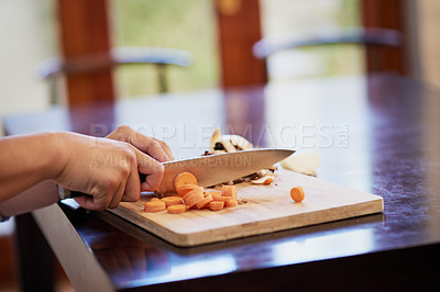 Buy stock photo Closeup shot of an unrecognizable woman chopping carrots in a kitchen