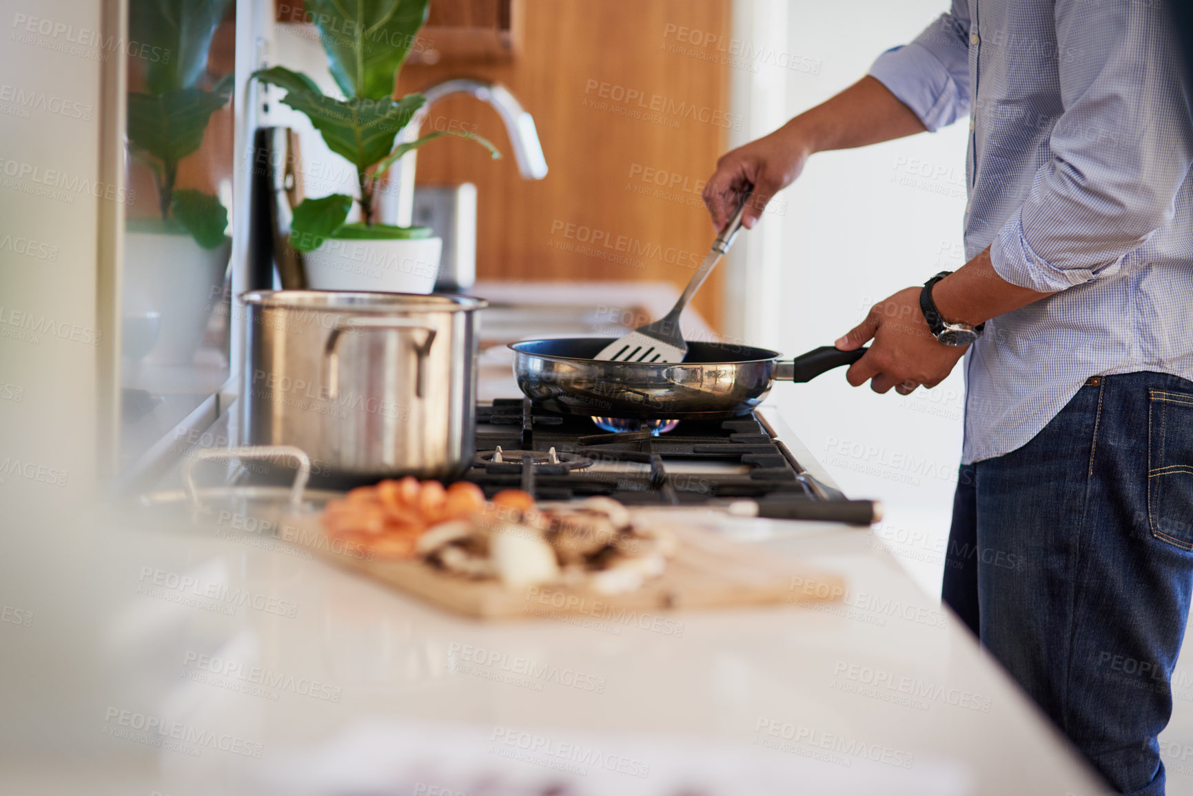 Buy stock photo Shot of an unrecognizable man cooking in the kitchen at home