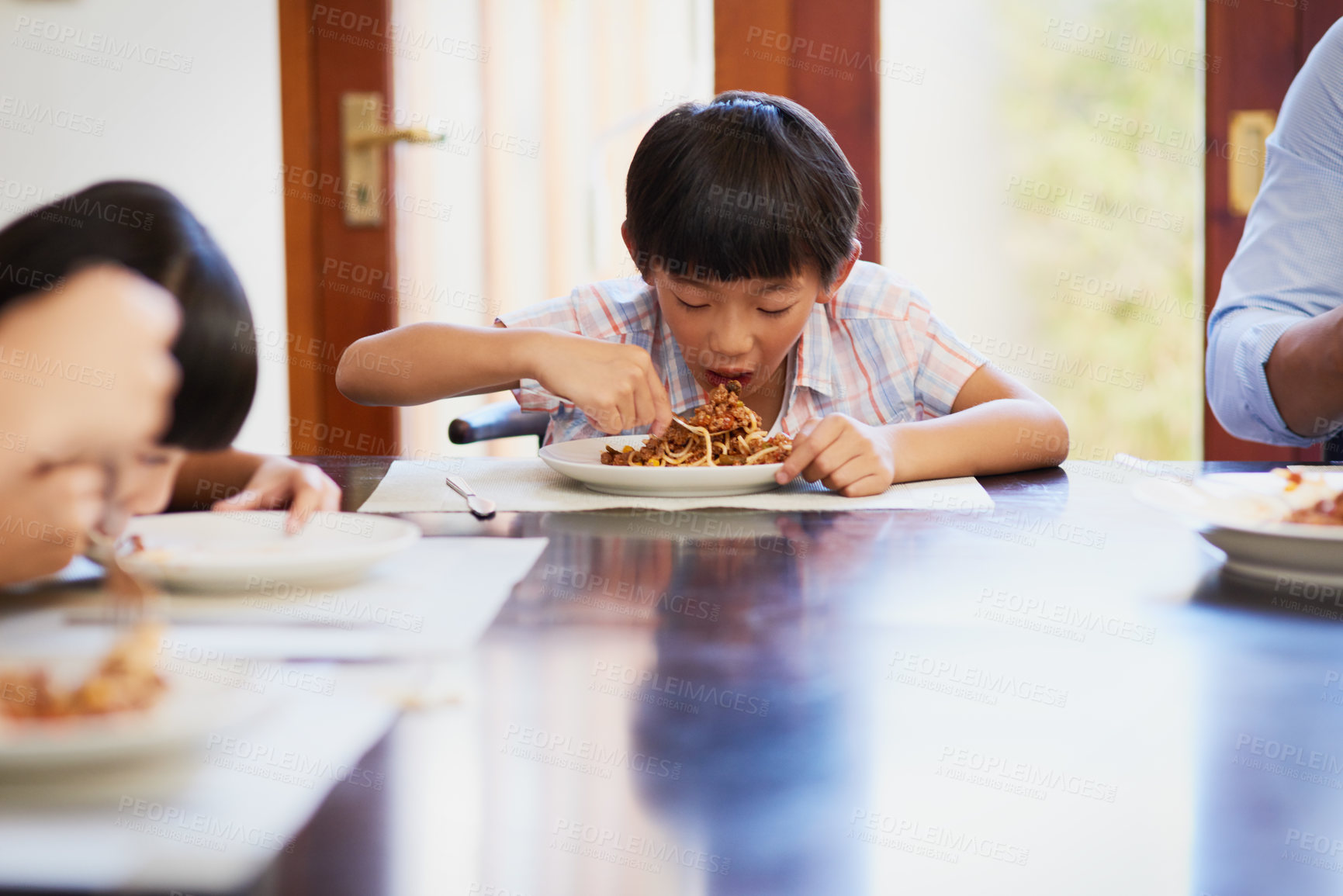 Buy stock photo Asian boy, food and children eating in dining room for nutrition, dinner or spaghetti. Hunger, wellness and happy kids with plate at table for healthy meal, noodles or growth development in home