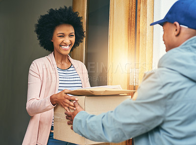 Buy stock photo Shot of a young woman receiving her delivery from the courier