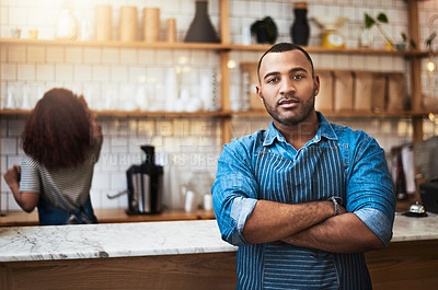 Buy stock photo Cropped portrait of a handsome young man standing with his arms folded in his coffee shop