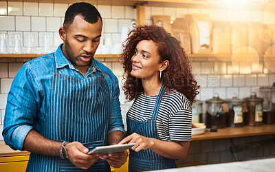 Buy stock photo Cropped shot of an affectionate young couple working on a tablet in their coffee shop