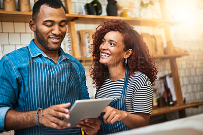 Buy stock photo Cropped shot of an affectionate young couple working on a tablet in their coffee shop